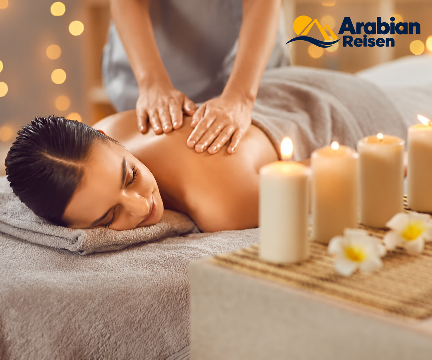Relaxing massage experience with candles and the Arabian Reisen logo